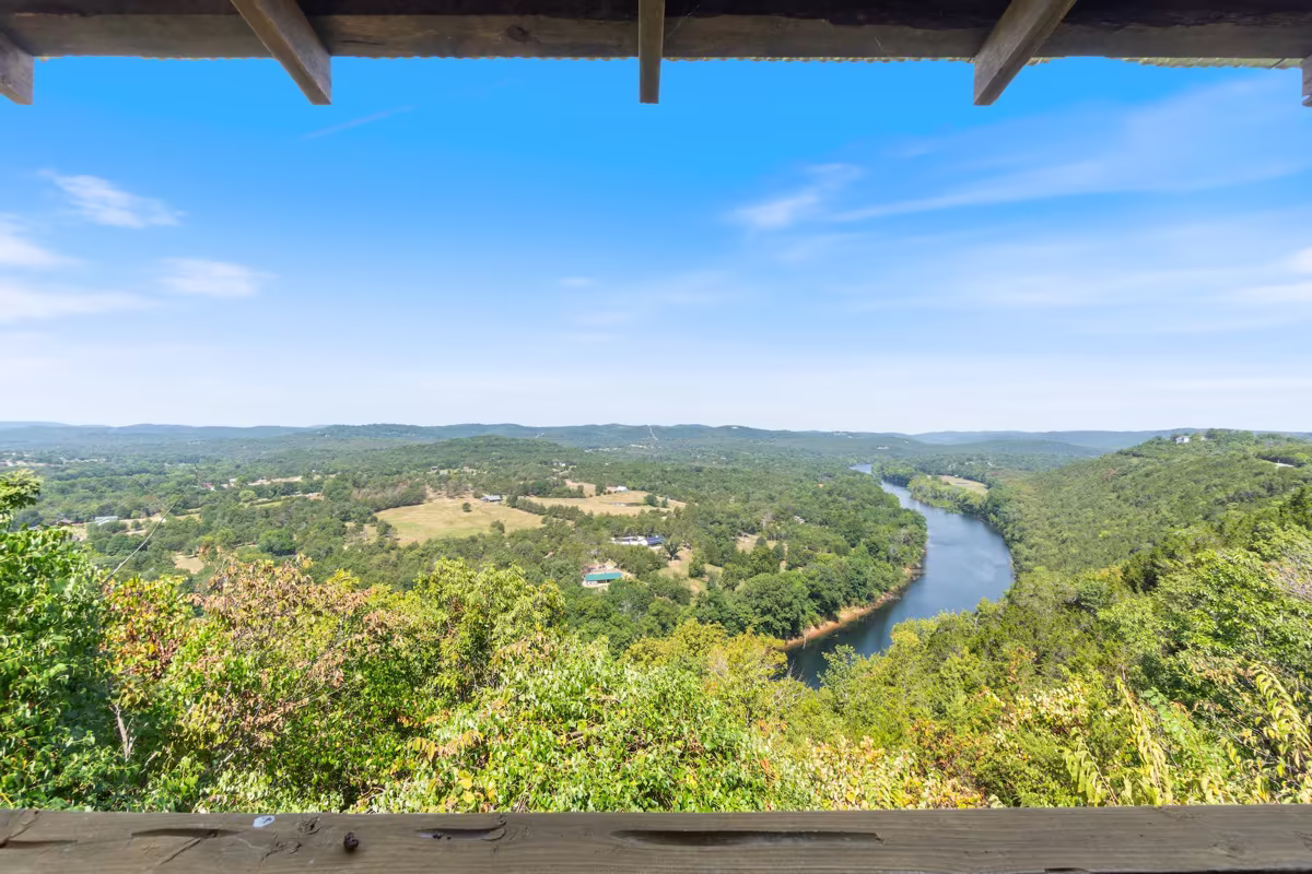 Covered cabin porch with rocking chairs overlooking the Ozark hills